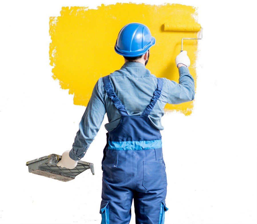 Profissional com capacete azul pintando parede amarela em ambiente comercial